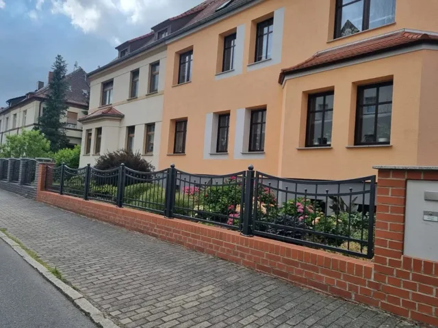 Dekorative Zaunfelder auf einem Backsteinsockel
