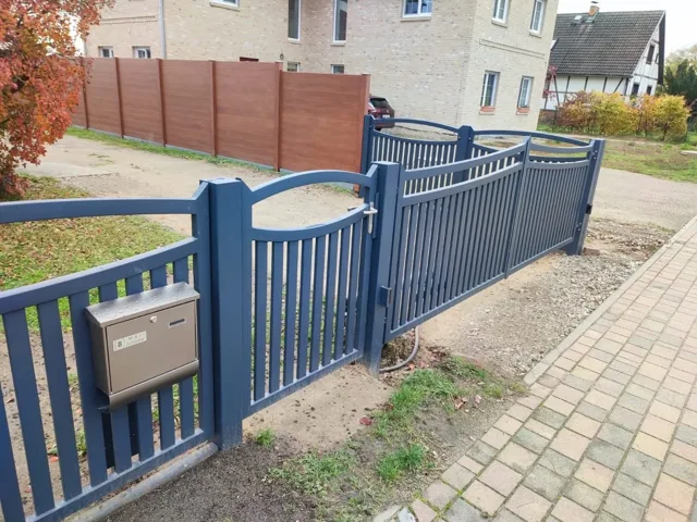 Blaugraue Gartentür mit gebogener Oberkante und Briefkasten