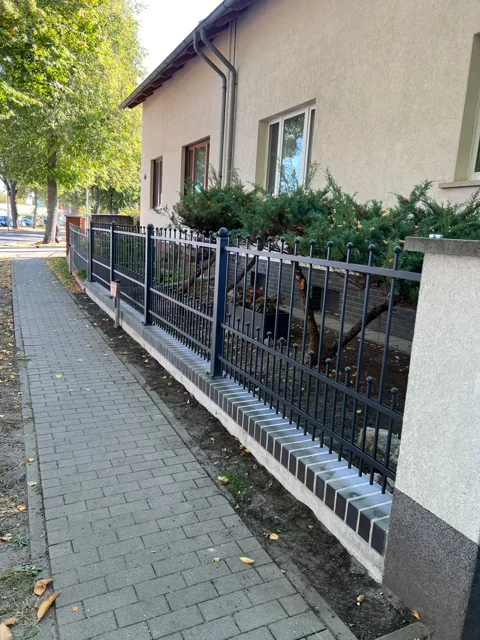 Metallzaun mit senkrechten Stäben und Kugelabschlüssen
