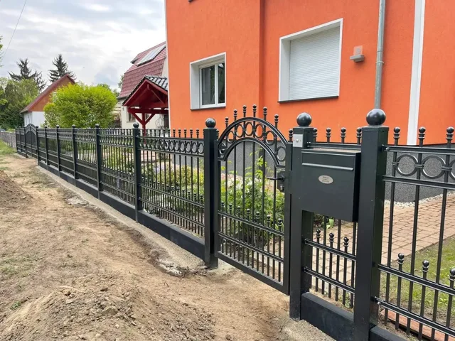 Metallgartentür und Zaun mit dekorativen Bögen